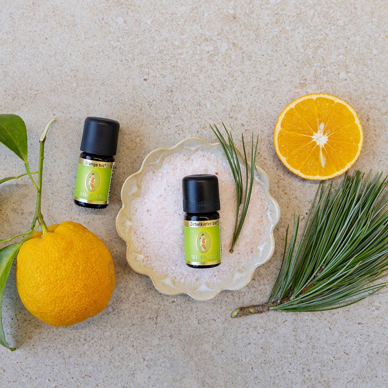 Orange bio und Zirbelkiefer bio dekoriert mit einem Teller salz, Kiefernadeln und Orangen