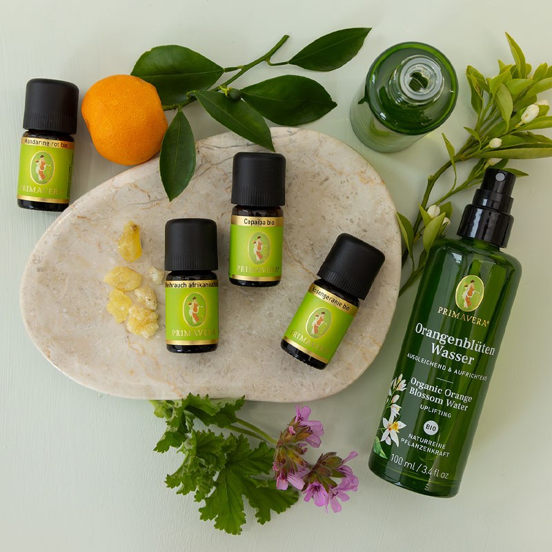 Zutaten für eine DIY‑Schüttelemulsion mit Copaiba, Weihrauch, Rosengeranie und Orangenblütenwasser.