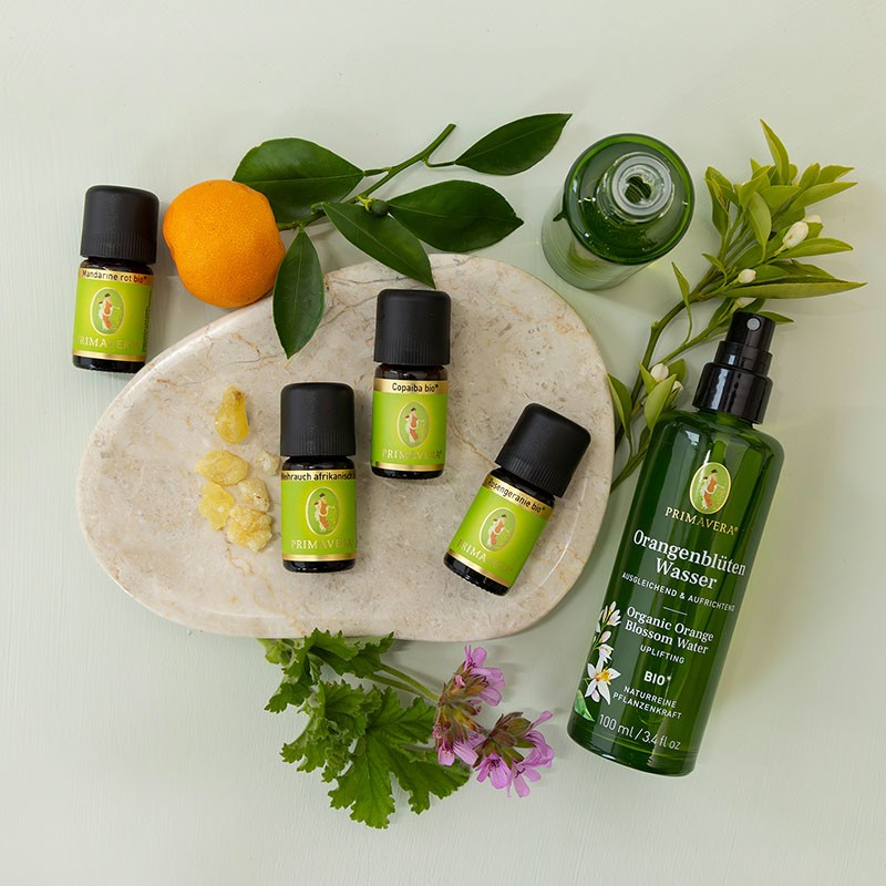 Zutaten für eine DIY‑Schüttelemulsion mit Copaiba, Weihrauch, Rosengeranie und Orangenblütenwasser.