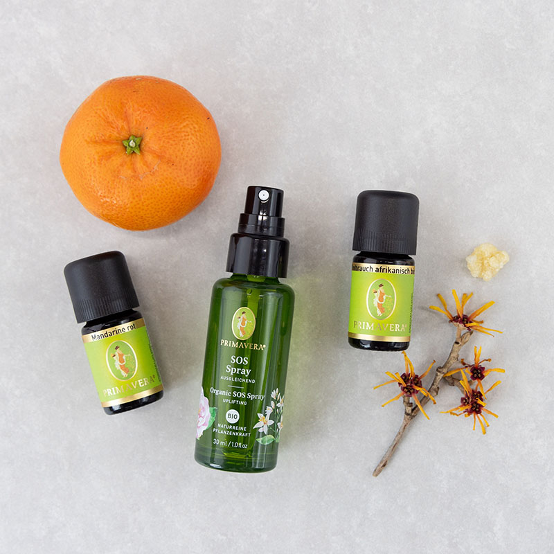 SOS Spray Bio und ätherische öle Mandarine rot und Weihrauch afrikanisch, dekoriert mit Mandarine, Hamamelis-Zweig und Weihrauch auf hellem Hintergrund.